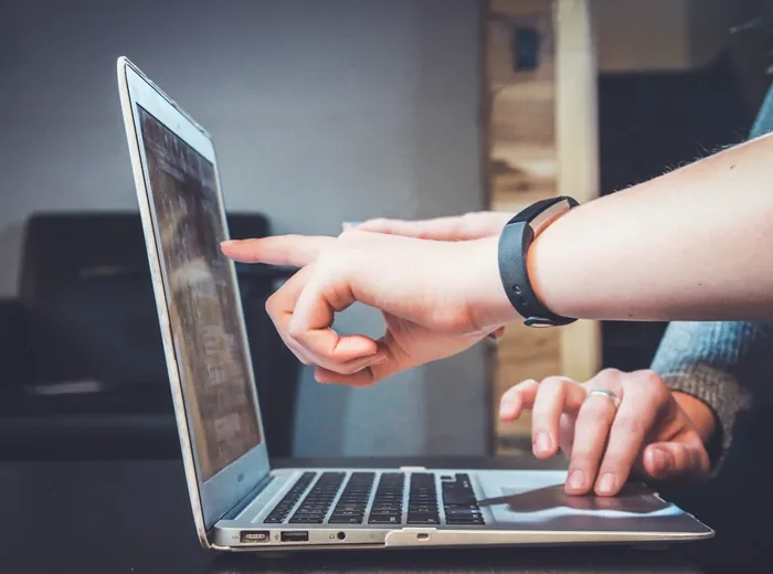 Two people reviewing patient paperwork together at a laptop